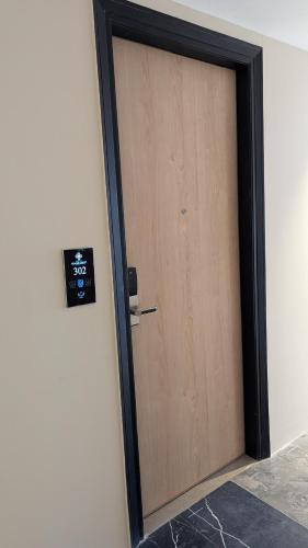 a wooden door with a clock on a wall at Hotel Grande Court in Kharar