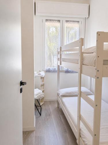 a bedroom with two bunk beds and a window at Solution Timone - Appartamento al mare in Punta Marina