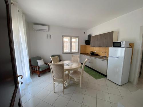 a kitchen with a table and a white refrigerator at Asfodelo in Galtellì