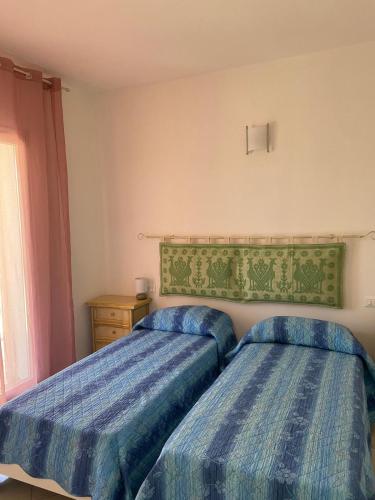 a bedroom with two beds and a window at Asfodelo in Galtellì