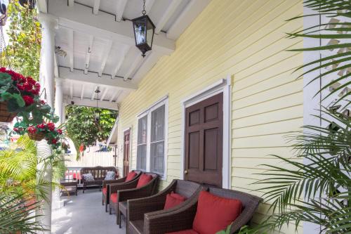 um alpendre com cadeiras e uma porta numa casa em Wicker Guesthouse em Key West