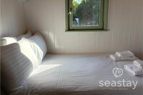 a bed in a room with two towels on it at Sea Farm Stays in Broadstairs