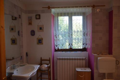 a bathroom with a sink and a toilet and a window at Casa del Zefiro in Sistiana