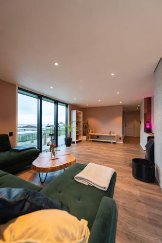 a living room with a green couch and a table at Lofoten Green House in Ramberg