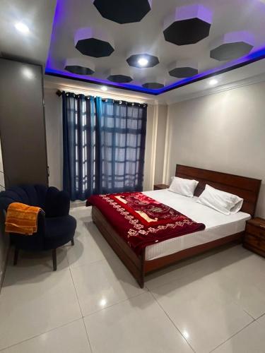 a bedroom with a large bed and a chair at Regal Heights in Bhurban