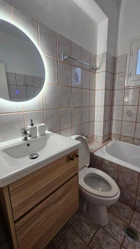 a bathroom with a sink and a toilet and a tub at Carte Postale Trikeri in Trikeri