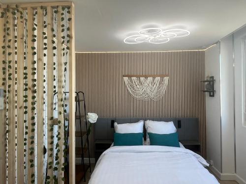 a bedroom with a bed with blue and white pillows at Studio Aloe horizon in Dunkerque