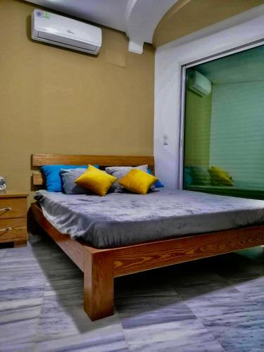 a bedroom with a bed with yellow and blue pillows at Hergla Diamond Kais in Sousse