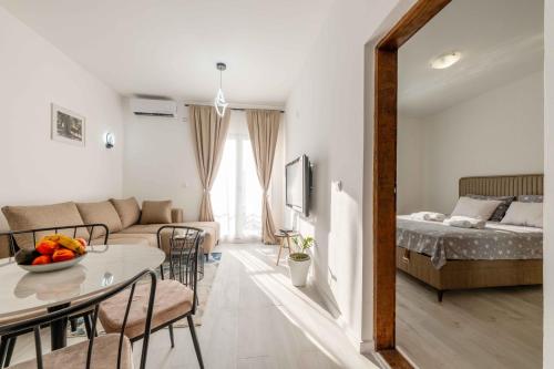 a living room with a couch and a table and a bed at Apartmani Oleander in Bar