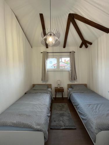 a bedroom with three beds and a chandelier at Villa Noor Visoko in Visoko