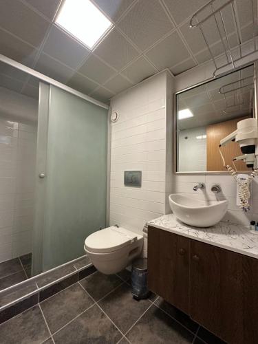 a bathroom with a toilet and a sink and a mirror at Mad Sea Beach Hotel in Şile