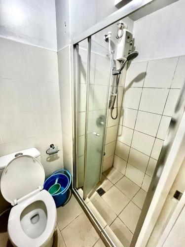 a bathroom with a toilet and a glass shower at SMDC Wind Residences Condo Unit by Bil & J's in Kaybagal