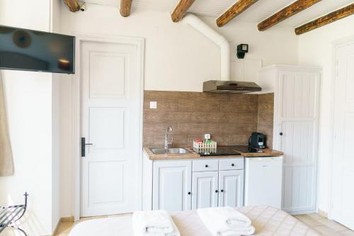 a kitchen with white cabinets and a sink at Athina Guesthouse in Hydra
