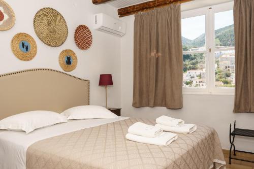 a bedroom with a bed with towels on it at Athina Guesthouse in Hydra