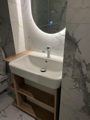 a white sink in a bathroom with a mirror at Adagio Studio Bar in Bar