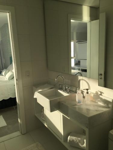 a bathroom with a sink and a mirror at Loft Barra in Porto Alegre