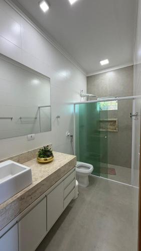 a bathroom with a shower and a sink and a toilet at Refúgio com Piscina e Vista Deslumbrante in Caconde