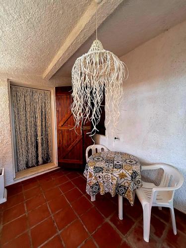 a table and chairs in a room with a chandelier at Casa Pineta in Rena Majore