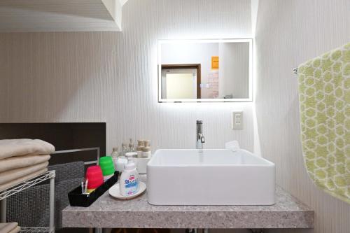a bathroom with a white sink and a mirror at Fuka in Beppu -New Open January2026 in Beppu