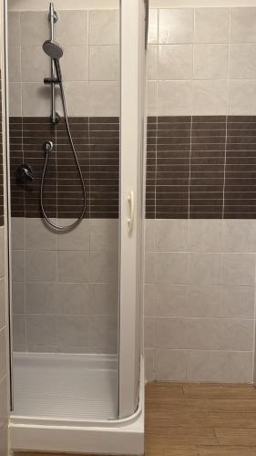 a shower in a bathroom with brown and white tiles at Casa della nonna in Pescara