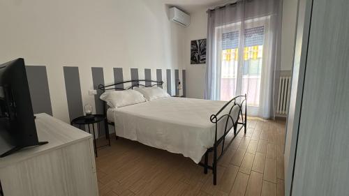 a bedroom with a bed and a flat screen tv at Casa della nonna in Pescara