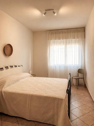 ein Schlafzimmer mit zwei Betten und einem Fenster in der Unterkunft Ā - Living in Valledoria