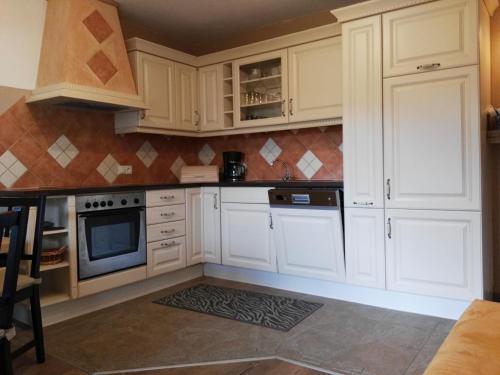 a kitchen with white cabinets and a microwave at Ferienwohnung Brugger in Zellberg
