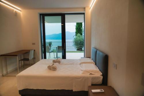 a bedroom with a bed and a large window at Villa Horizon in Torri del Benaco
