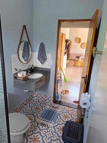 a bathroom with a toilet and a sink and a mirror at Chalé Araucárias-Recanto dos pássaros in Cambuí
