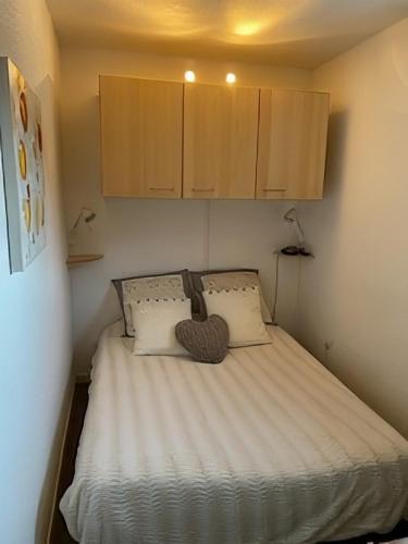 a small bedroom with a bed with a heart pillow at Location duplex ,Station du Seignus d'Allos in Allos