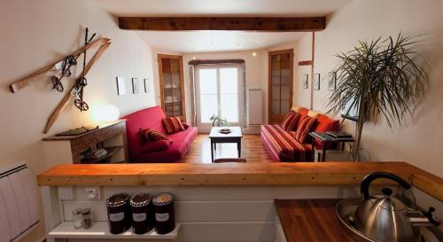 a living room with red couches in a room at Historic Centre Studio, St-André & Bastille view! in Grenoble