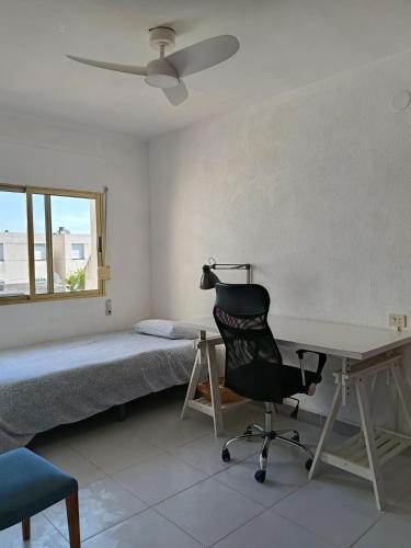a bedroom with a bed and a desk and a chair at Casa Cristina in Vinarós