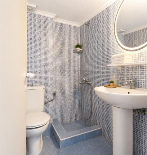 a blue tiled bathroom with a toilet and a sink at Ioli Beach in Skala Fourkas