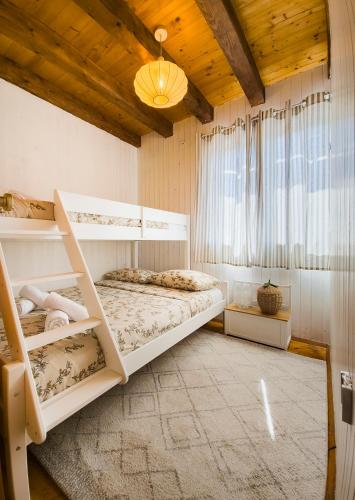 a bedroom with two bunk beds and a window at Velebit House in Baške Oštarije