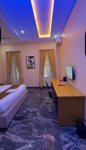 a room with a bed and a desk with a computer at FOURTOWERShotel in Ijoko Lemode