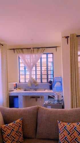 a living room with a couch and a large window at Moh airbnbs in Kisumu