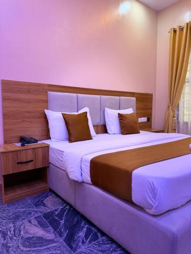 a bedroom with a large bed with a wooden headboard at FOURTOWERShotel in Ijoko Lemode