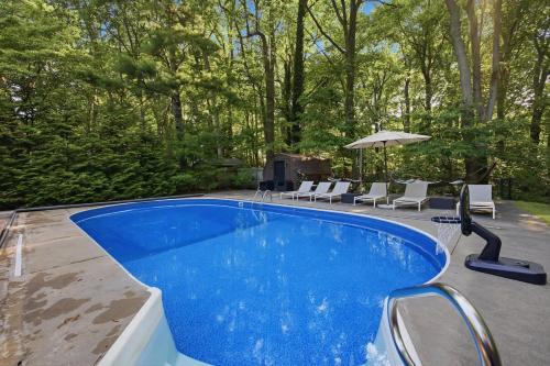 a swimming pool with chairs and an umbrella at Loma House in Sawyer