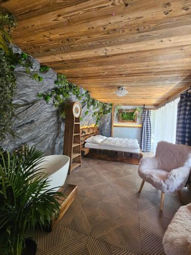a bedroom with a bed and a chair in a room at Chatka Bystrá jacuzzi,stars,river in Bystrá