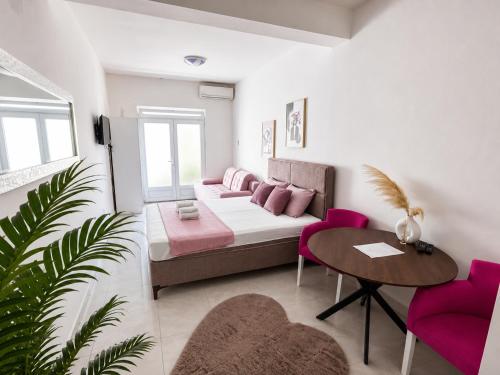 a living room with a bed and a table and chairs at Banićević APARTMANI in Đenovići