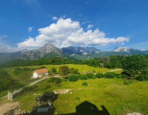 a truck parked in a field with mountains in the background at Guest House Avdi Kola in Gagu