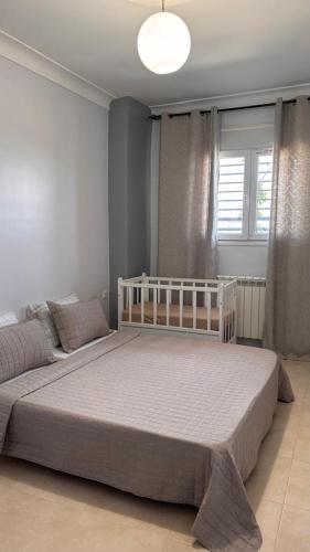 a bedroom with a white bed and a window at Studio Prestige - 10min de ParkMall in Sétif