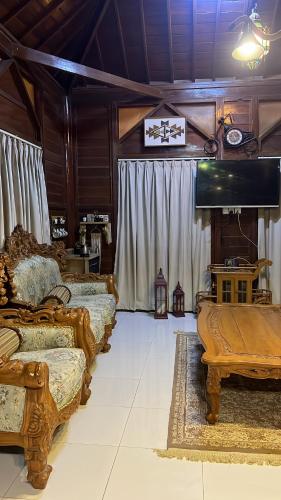 a living room with three beds and a piano at شالية الكوخ in Salalah