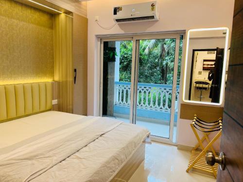 a bedroom with a bed and a balcony at Verdant vista Goa in Cunchelim