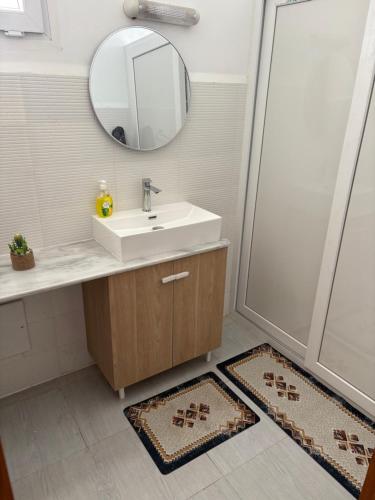 a bathroom with a sink and a mirror and two rugs at Talia in Bejaïa