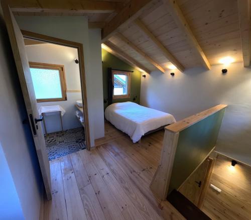 a small bedroom with a bed and a bathroom at Le Bâti in Servoz