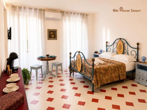 a bedroom with a bed and a table and chairs at Bibi House in Sassari