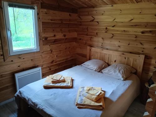 a bedroom with a bed in a log cabin at Le chalet d'Empeytepas in Céaux-dʼAllègre