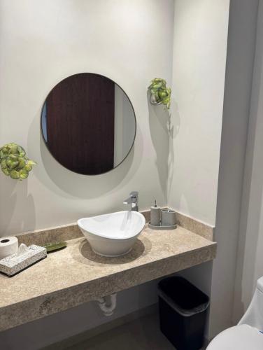 a bathroom with a white sink and a mirror at Departamento en Monné in Mérida