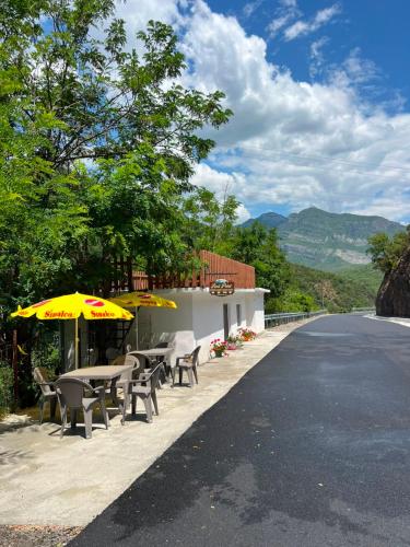 a table and chairs with umbrellas on the side of a road at Koman Rest Point in Koman